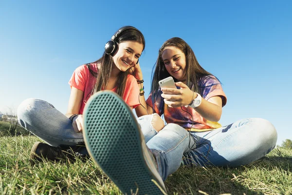 Heureux adolescent amis dans été parc écoute de la musique . — Photo