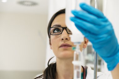 Yeşil elbisesi giymiş genç kadın doktor anestezi koyar 