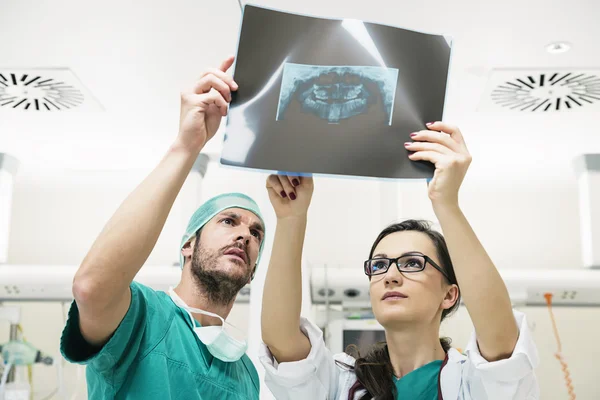 Medicine doctor showing something to her male colleague on x-ray — Stock Photo, Image