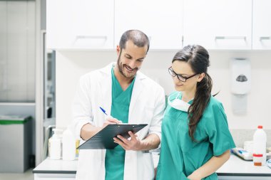 Doktor ve hemşire hastanın raporu inceleyerek