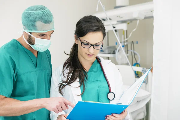 Trabalhadores da equipe médica examinando um relatório médico — Fotografia de Stock