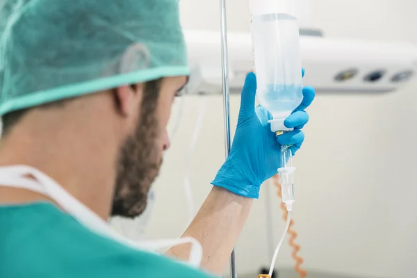 Jovem médico anestesiologista vestido com vestido verde, coloca th — Fotografia de Stock