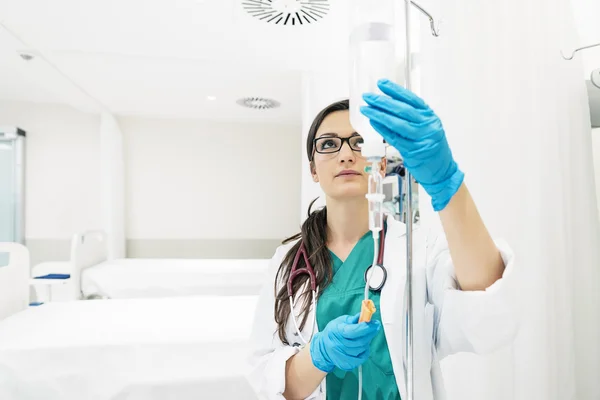 Jovem médico anestesiologista vestido com vestido verde, coloca — Fotografia de Stock