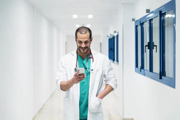 Belo médico escrevendo no celular no hospital — Fotografia de Stock
