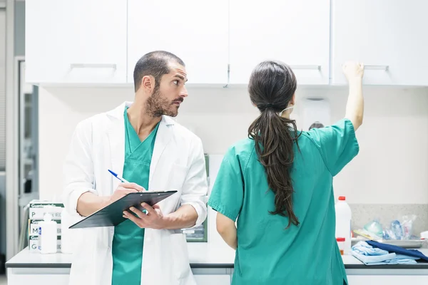 Doctor and nurse examining report of patient — Stock Photo, Image