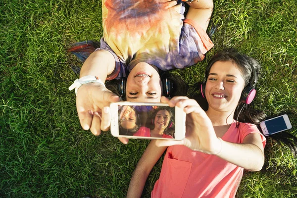 Две девочки-подростки делают селфи в парке — стоковое фото