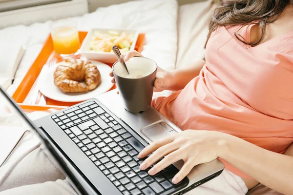Γυναίκα βλέποντας το φορητό υπολογιστή και το πρωινό. — Φωτογραφία Αρχείου