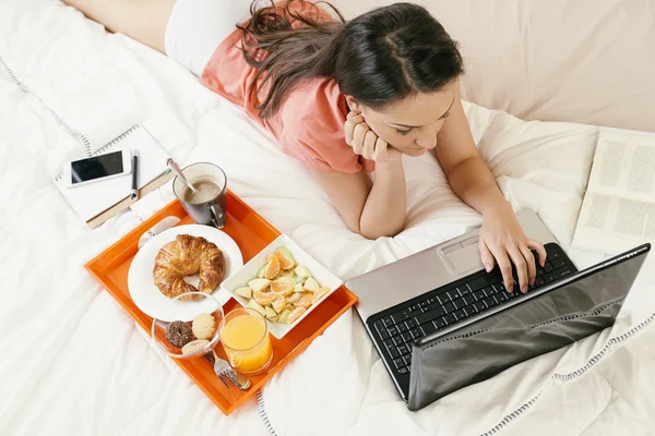 Nő a laptop számítógép figyeli és reggelizik — Stock Fotó