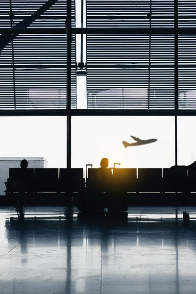 Silhouettes de personnes attendant aux portes d'embarquement de l'avion . — Photo