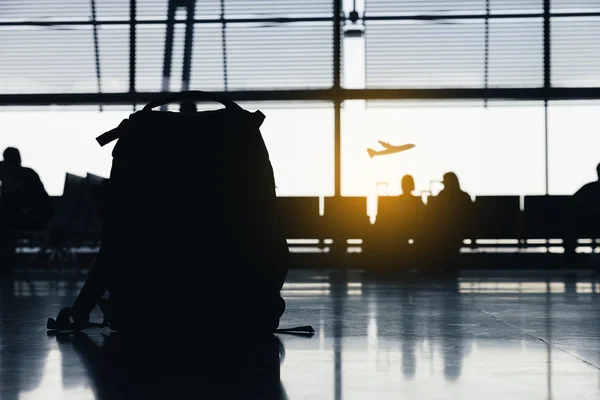 Silhouettes de personnes attendant aux portes d'embarquement de l'avion . — Photo