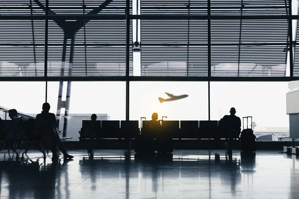 Silhouetten von Menschen, die am Flugsteig warten. — Stockfoto