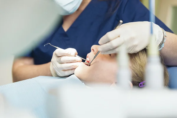 Dentistas con un paciente durante una intervención dental a una niña . —  Fotos de Stock