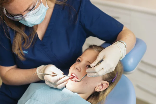 Dentistas com um paciente durante uma intervenção dentária para menina . — Fotografia de Stock