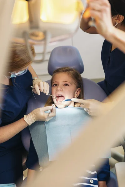 Kız bir diş müdahale sırasında bir hastayla diş hekimleri. — Stok fotoğraf