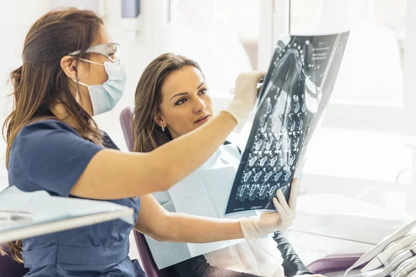 Dokter praat met haar patiënt en het onderwijzen van een radiografie. — Stockfoto