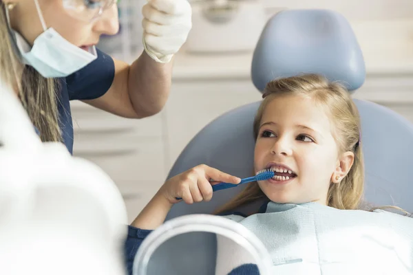 Врач-дантист учит ребенка чистить зубы . — стоковое фото