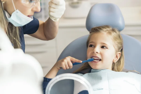 Médecin dentiste enseignant à un enfant à se brosser les dents . — Photo