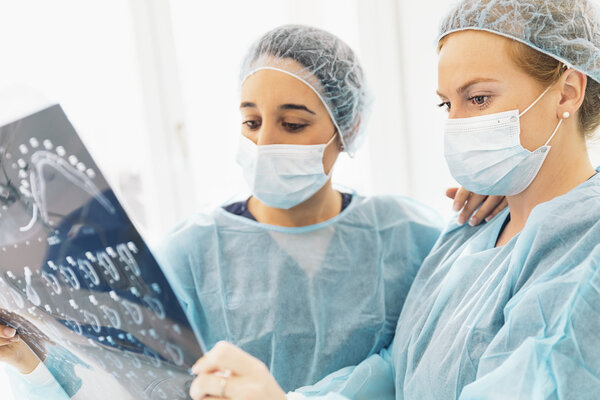 Dentist doctor showing something to her colleague on x-ray image