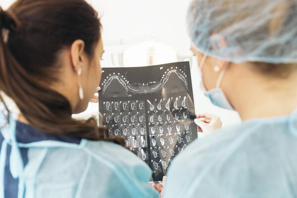 Dentist doctor showing something to her colleague on x-ray image