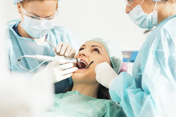 Dentistas com um paciente durante uma intervenção dentária . — Fotografia de Stock