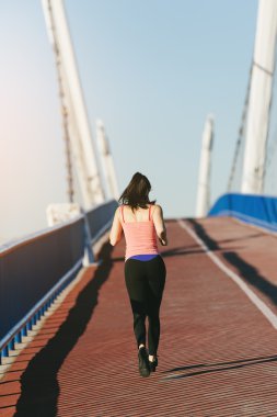 Şehir Köprüsü üzerinde çalışan genç fitness kadın runner.