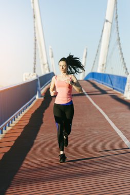 Şehir Köprüsü üzerinde çalışan genç fitness kadın runner.
