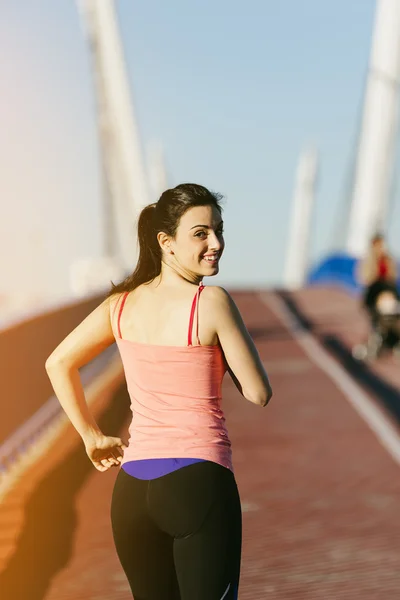 Joven corredor de fitness mujer corriendo en puente de la ciudad . — Foto de Stock