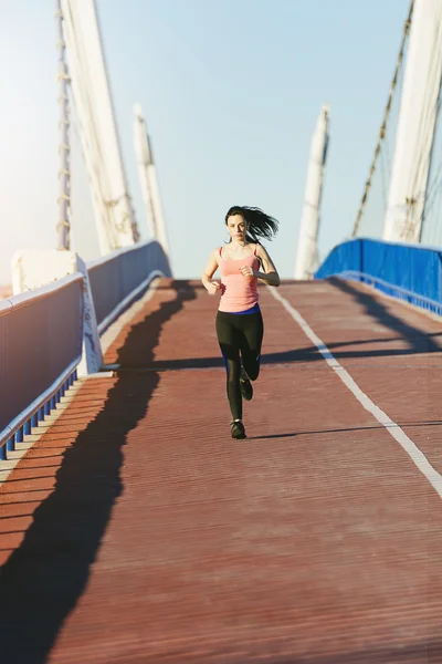 Joven corredor de fitness mujer corriendo en puente de la ciudad . — Foto de Stock