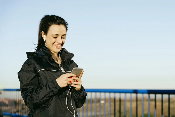 Joven corredora escuchando música durante la carrera — Foto de Stock