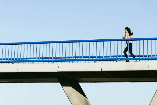 Joven corredor de fitness mujer corriendo en puente de la ciudad . — Foto de Stock