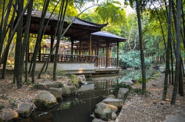 Bambu ormanında bir derenin yanındaki ahşap sığınak. Suzhou, Çin