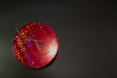 Yuvarlak ve kırmızı kapalı hediye kutusu siyah arkaplan üzerinde izole özel durumlar için metin eklemek için boşluk ile