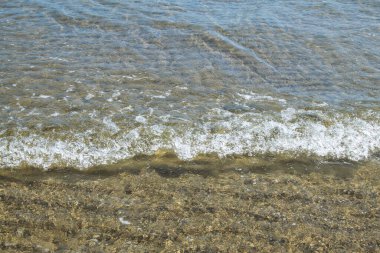 Sahilin kıyısında kopan bir okyanus dalgasının köpüğü. Arkaplan ve element tasarımı