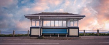 Gün batımında banklı güzel bir otobüs durağı manzarası. 