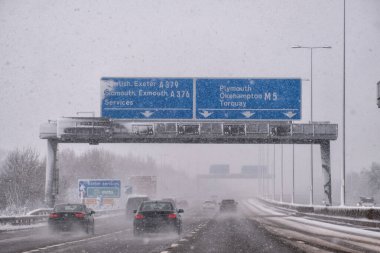 Karla kaplı nehirden geçen kış yolu, arabalar. 