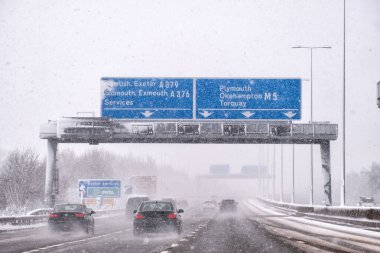 Karla kaplı nehirden geçen kış yolu, arabalar. 
