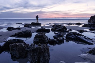 Sahilde bir adamın silueti. 