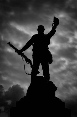 Bulutlu arka planda asker heykelinin dramatik siyah beyaz görüntüsü