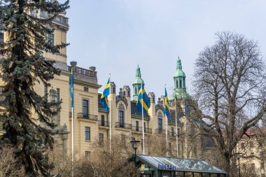Stockholm, İsveç - 27 Mart 2021: Eski polis binasının önünde dalgalanan İsveç bayrakları