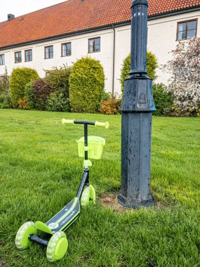 Vadstena, İsveç - 22 Mayıs 2021: Küçük çocuklar için yeşil scooter