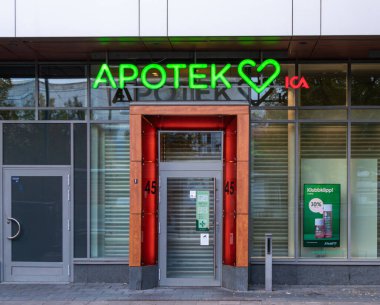Stockholm, İsveç - 18 Ekim 2025: Stockholm 'de neon ışıklı ve cam kapılı modern bir eczane.