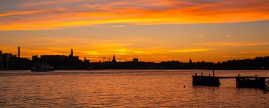 Gün batımında parlak turuncu gökyüzü ile gökyüzü silueti.