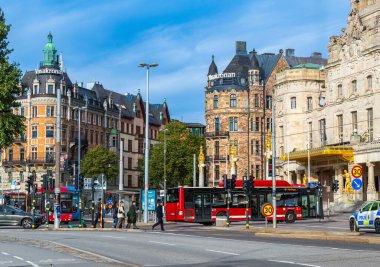 Stockholm, İsveç - 11 Ekim 2025: Tarihi binalar, otobüsler ve yayaların bulunduğu şehir caddesi.