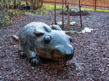 Nyckelviken, İsveç - 14 Aralık 2025: Ahşap bir sıçan heykeli saman ve ağaçlarla kaplı bir bahçede.