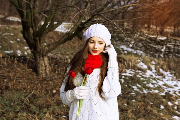 Spring portrait of a girl with red tulips — Stock Photo, Image