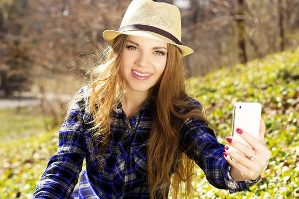 Красива молода блондинка в капелюсі з телефоном — стокове фото