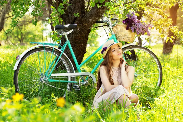 Menina bonita em um chapéu em uma bicicleta vintage — Fotografia de Stock