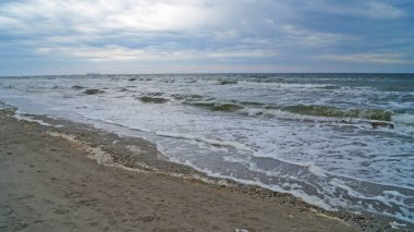 Dalgalı ve beyaz köpüklü Karadeniz Mavi gökyüzünün altında Bulutların arasında Bulutlu bir bahar günü