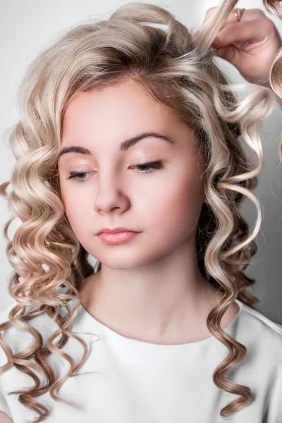 Corda de cabelo louro encaracolado em seu braço — Fotografia de Stock