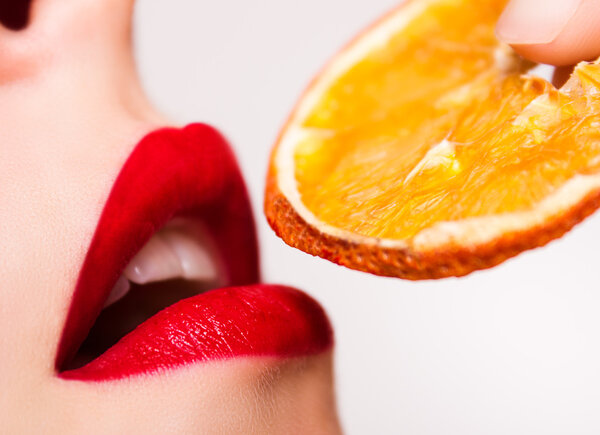 Red lips touch the orange
